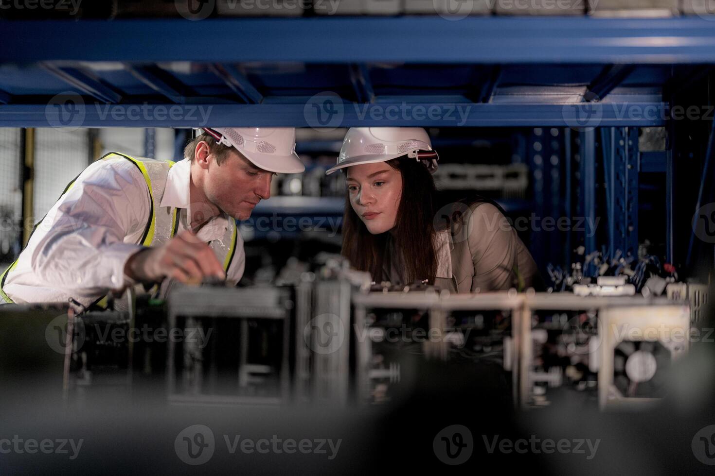 checking and inspecting metal machine part items for shipping. male and woman worker checking the store factory. industry factory warehouse. The warehouse of spare part for machinery and vehicles. photo