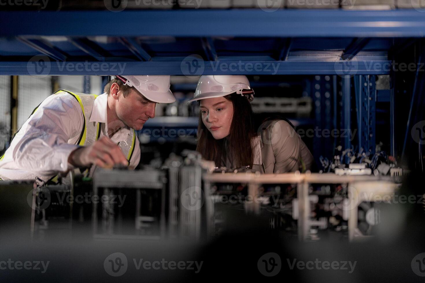 checking and inspecting metal machine part items for shipping. male and woman worker checking the store factory. industry factory warehouse. The warehouse of spare part for machinery and vehicles. photo