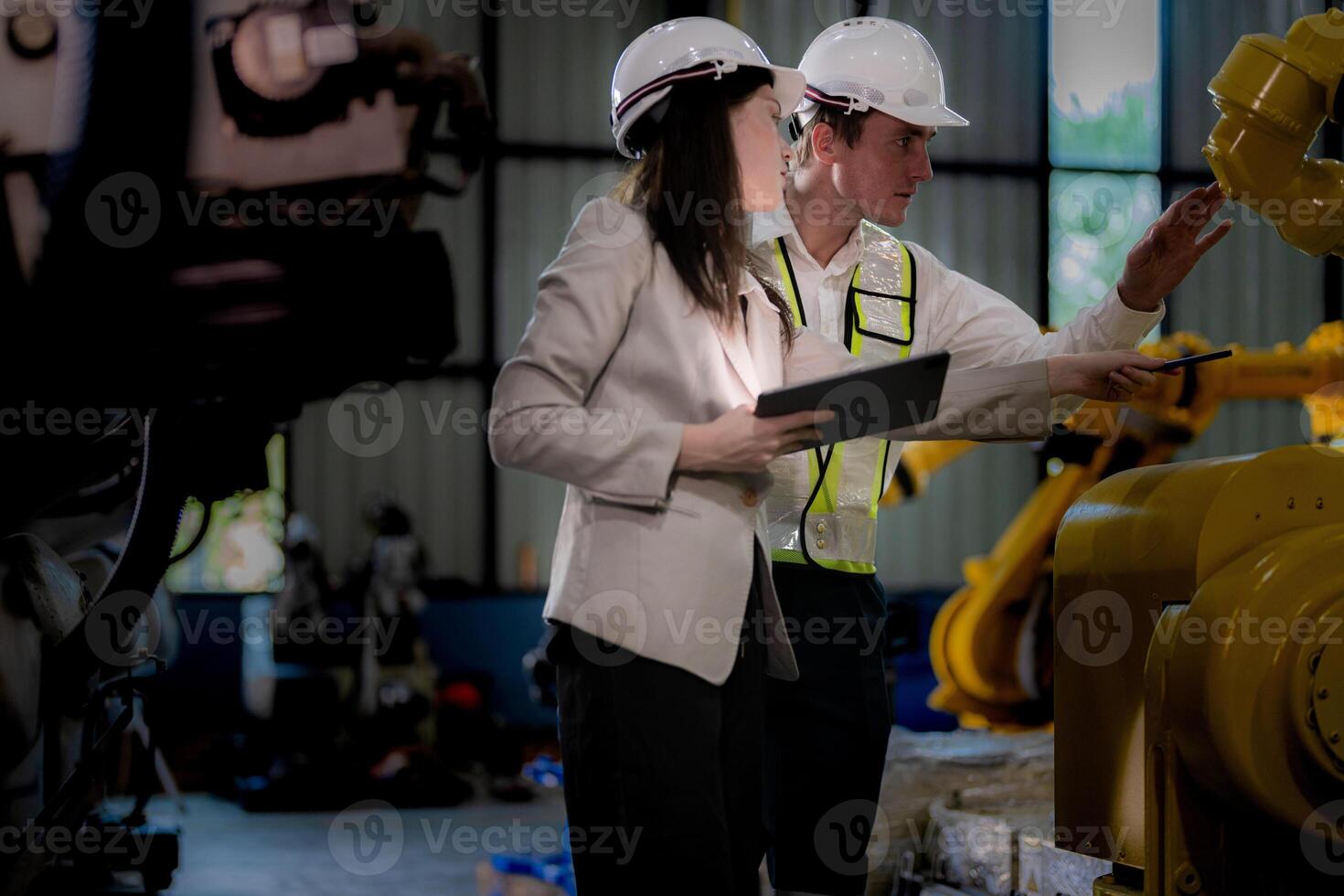 Business woman and man meeting and checking new machine robot. Engineer walking at warehouse industry machine. business negotiation concepts and technology. woman is Using smart Tablet to present man. photo