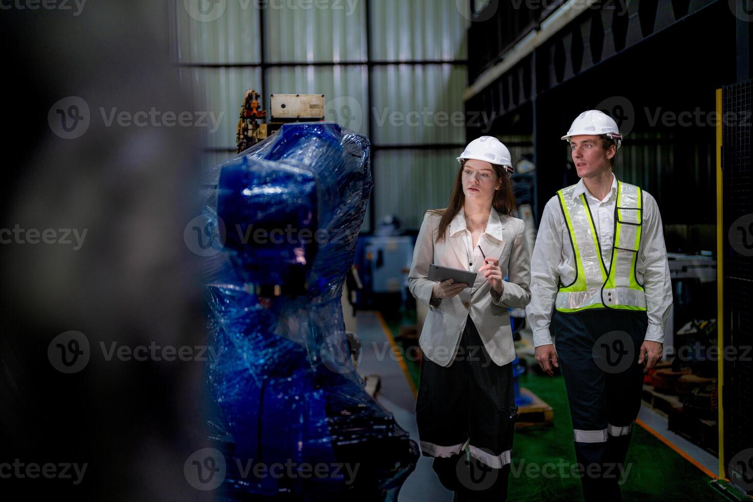 Business woman and man meeting and checking new machine robot. Engineer walking at warehouse industry machine. business negotiation concepts and technology. woman is Using smart Tablet to present man. photo