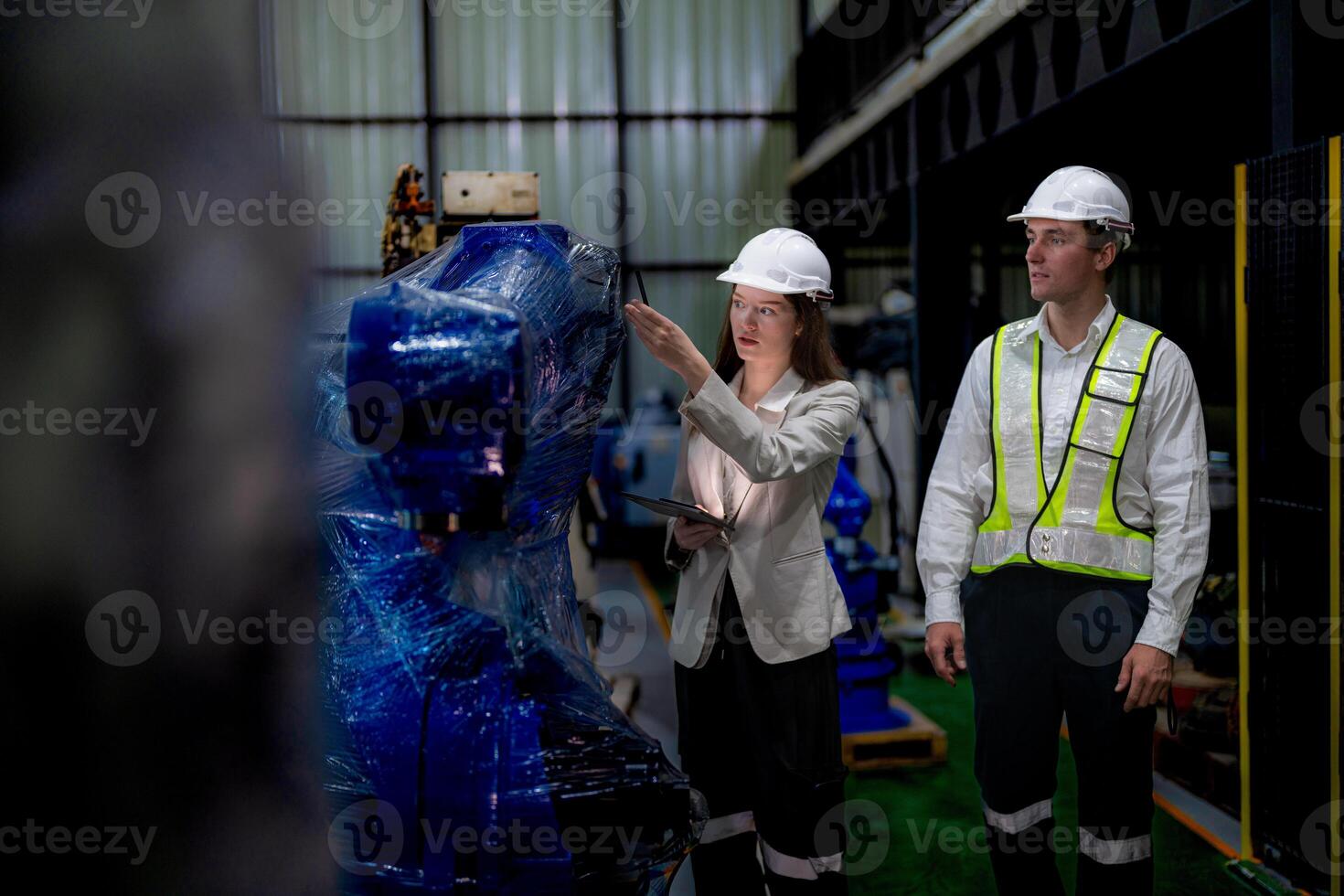 Business woman and man meeting and checking new machine robot. Engineer walking at warehouse industry machine. business negotiation concepts and technology. woman is Using smart Tablet to present man. photo