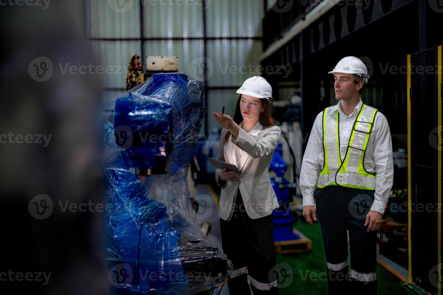 Business woman and man meeting and checking new machine robot. Engineer walking at warehouse industry machine. business negotiation concepts and technology. woman is Using smart Tablet to present man. photo