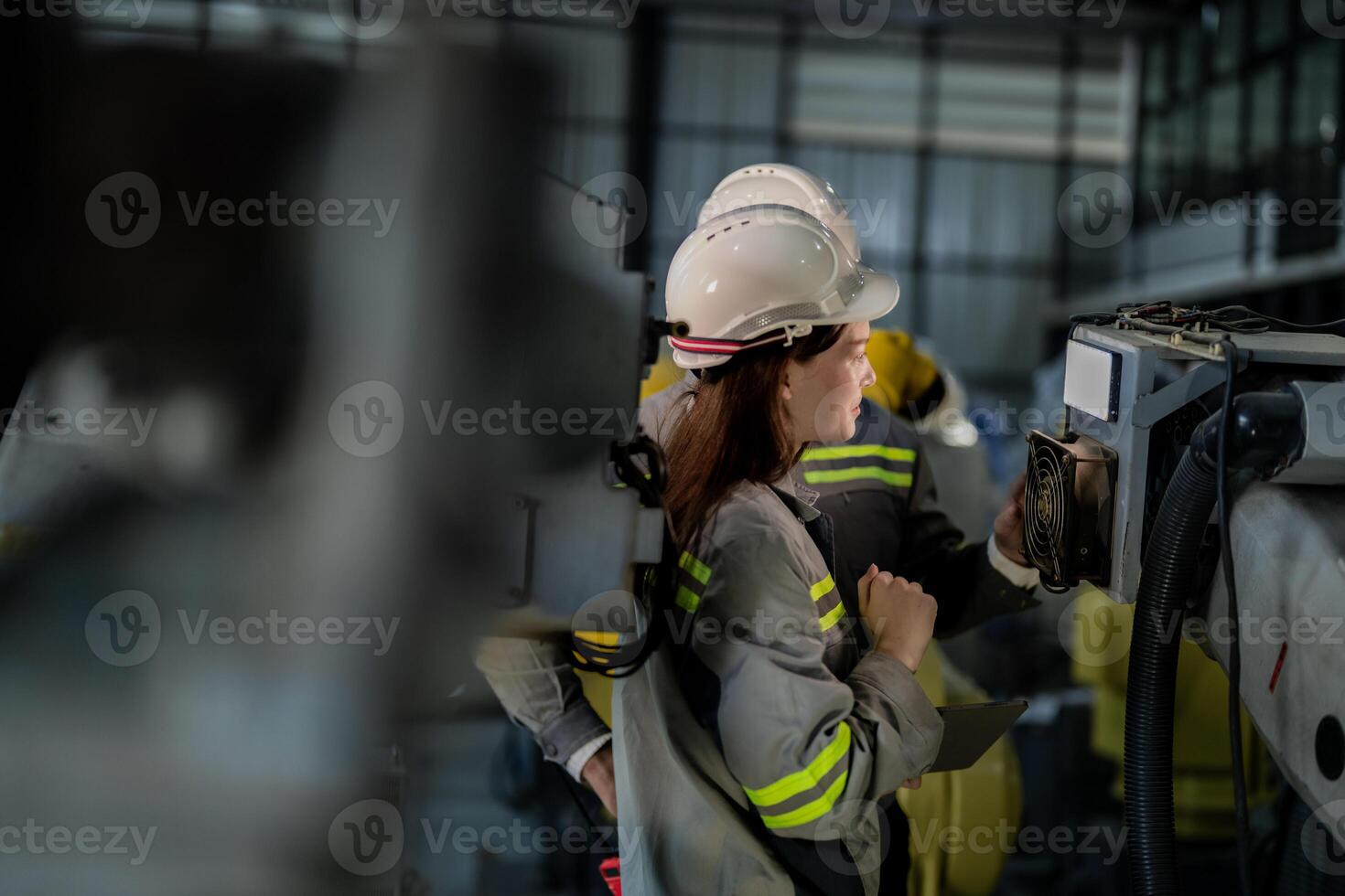 ingenieros cheque controlar pesado máquina robot brazo. diverso equipo de industrial robótica ingenieros reunido alrededor máquina. profesional maquinaria operadores reparar eléctrico robot en brillante digital panel. foto