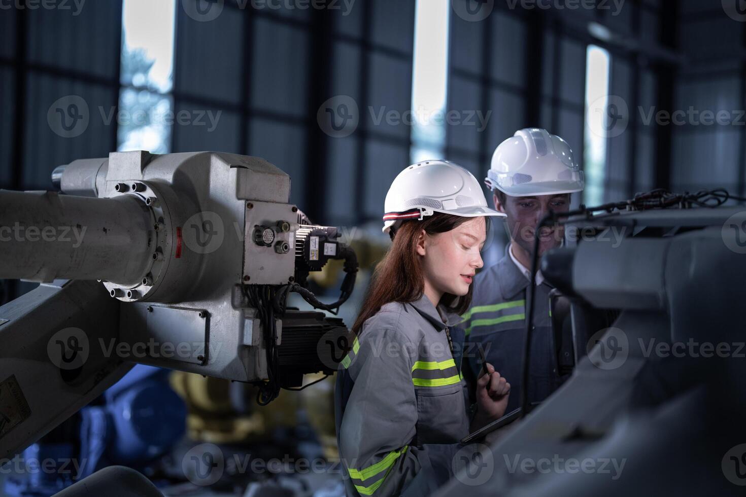 engineers check control heavy machine robot arm. Diverse Team of Industrial Robotics Engineers Gathered Around Machine. Professional Machinery Operators repair electric robot on bright digital panel. photo