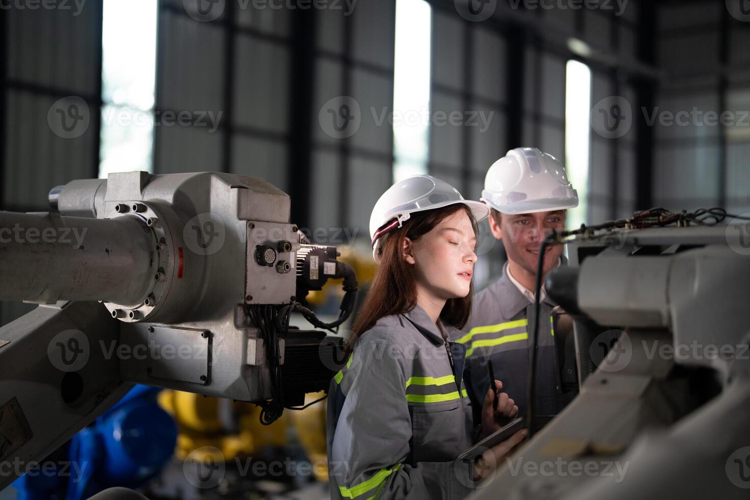 engineers check control heavy machine robot arm. Diverse Team of Industrial Robotics Engineers Gathered Around Machine. Professional Machinery Operators repair electric robot on bright digital panel. photo