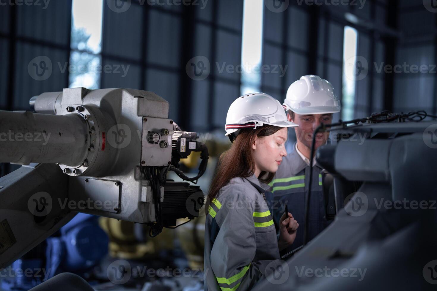 engineers check control heavy machine robot arm. Diverse Team of Industrial Robotics Engineers Gathered Around Machine. Professional Machinery Operators repair electric robot on bright digital panel. photo