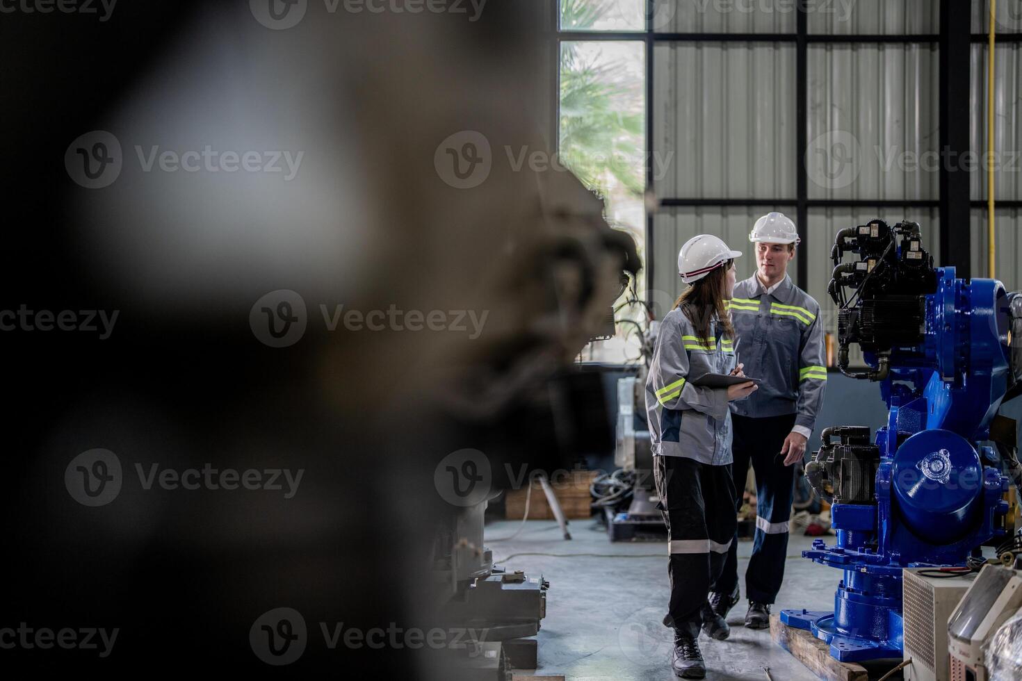 ingenieros cheque controlar pesado máquina robot brazo. diverso equipo de industrial robótica ingenieros reunido alrededor máquina. profesional maquinaria operadores reparar eléctrico robot en brillante digital panel. foto