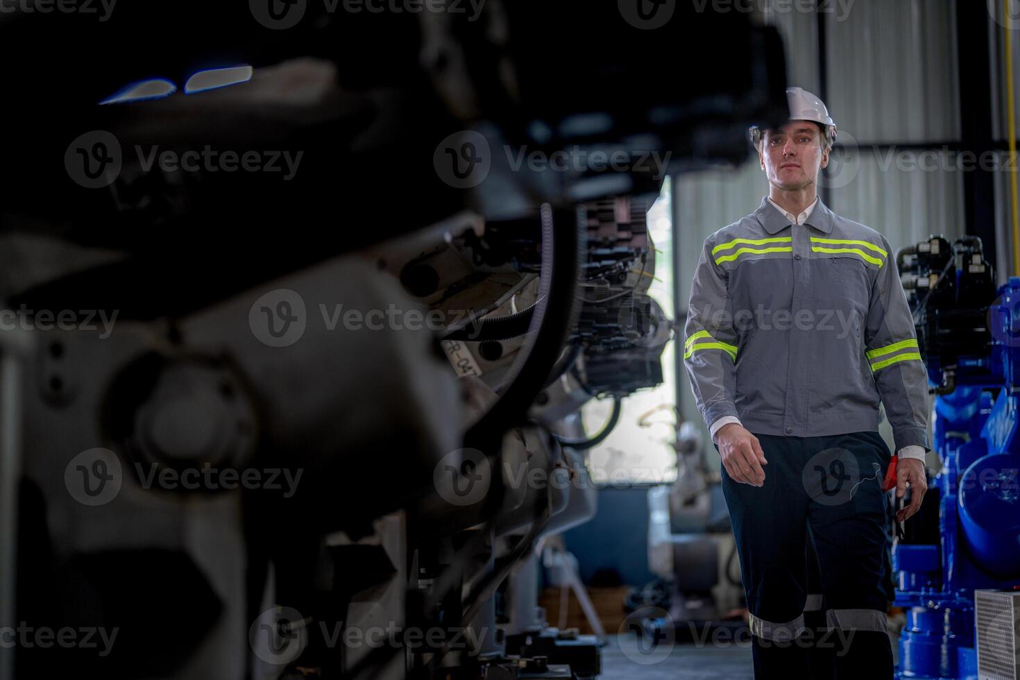 Factory engineer woman inspecting on machine with smart tablet. Worker works at machine robot arm. The welding machine with a remote system in an industrial factory. Artificial intelligence concept. photo