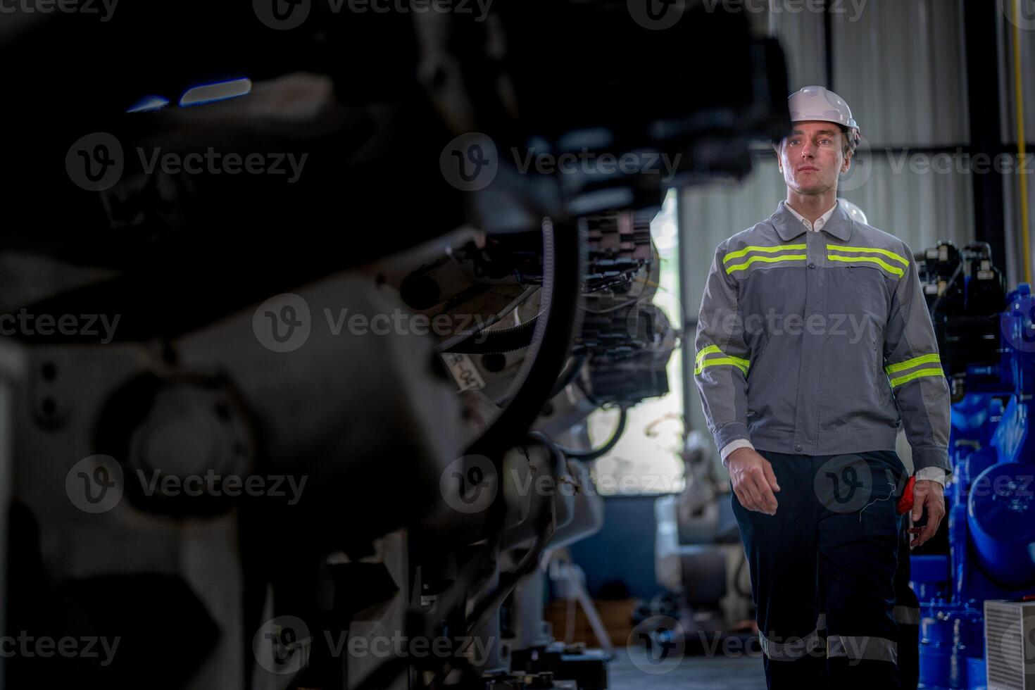 Factory engineer woman inspecting on machine with smart tablet. Worker works at machine robot arm. The welding machine with a remote system in an industrial factory. Artificial intelligence concept. photo