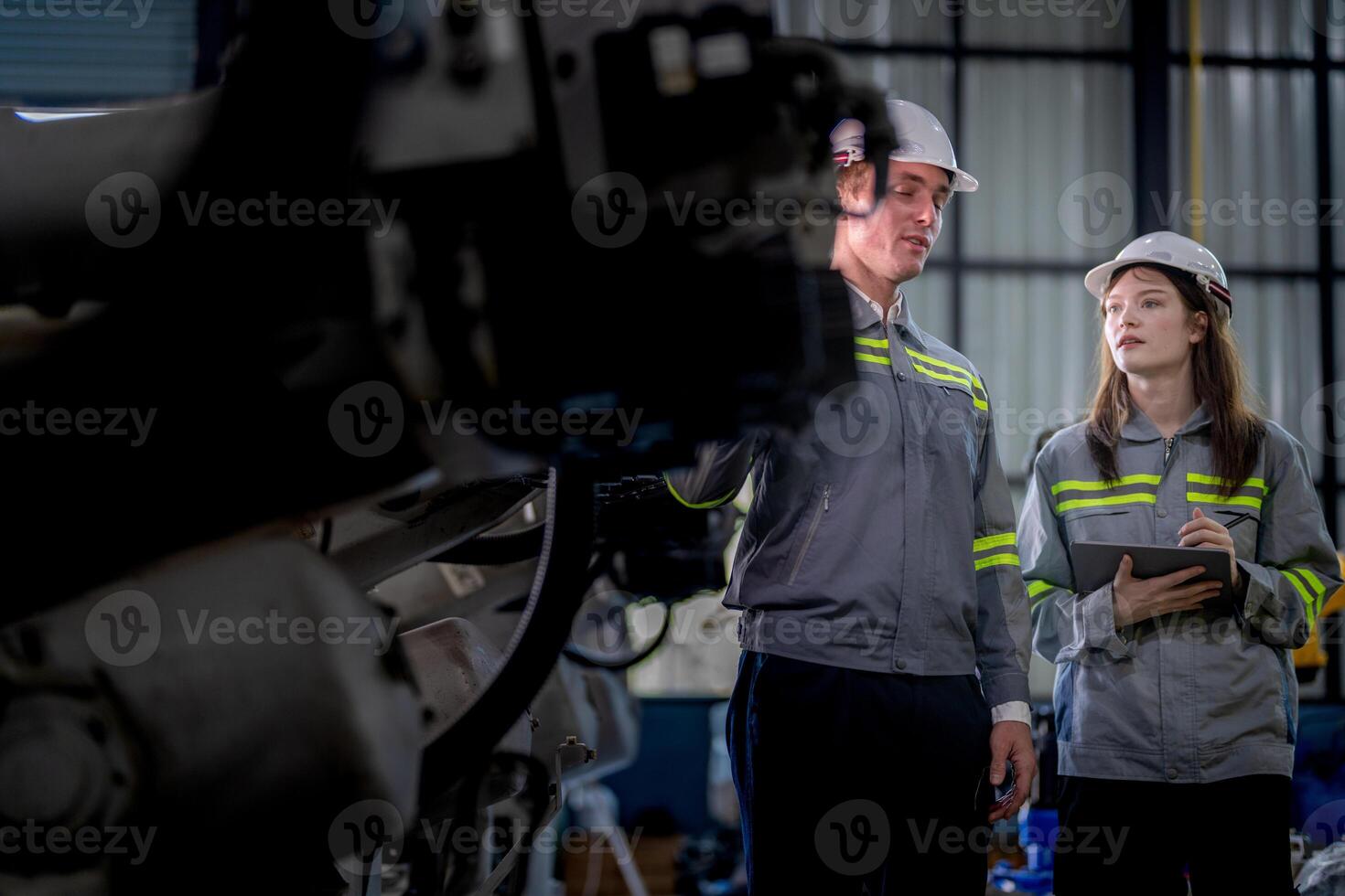 engineers check control heavy machine robot arm. Diverse Team of Industrial Robotics Engineers Gathered Around Machine. Professional Machinery Operators repair electric robot on bright digital panel. photo