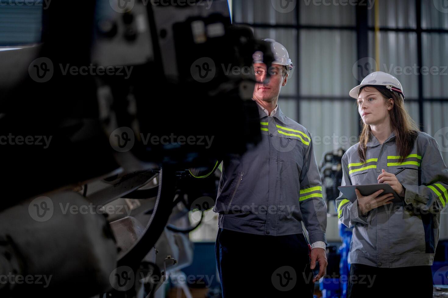 engineers check control heavy machine robot arm. Diverse Team of Industrial Robotics Engineers Gathered Around Machine. Professional Machinery Operators repair electric robot on bright digital panel. photo