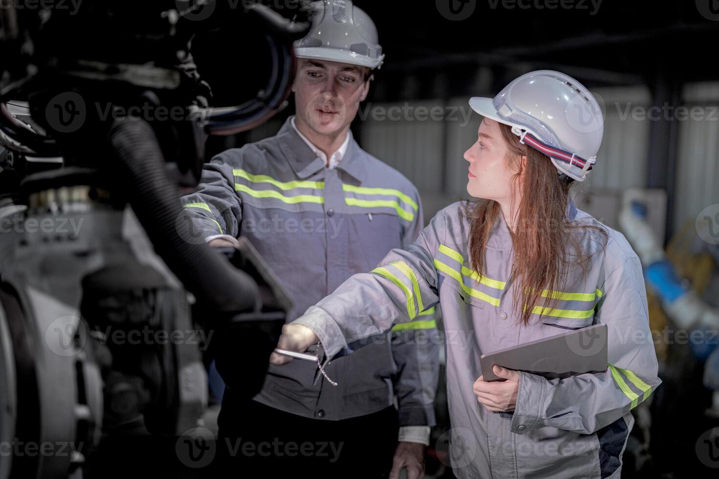Business engineers meet and check control heavy machine robot arm. Diverse Team of Industrial Robotics Engineers Gathered Around machine. Professional Machinery Operator Use Industrial Digital Tablet. photo