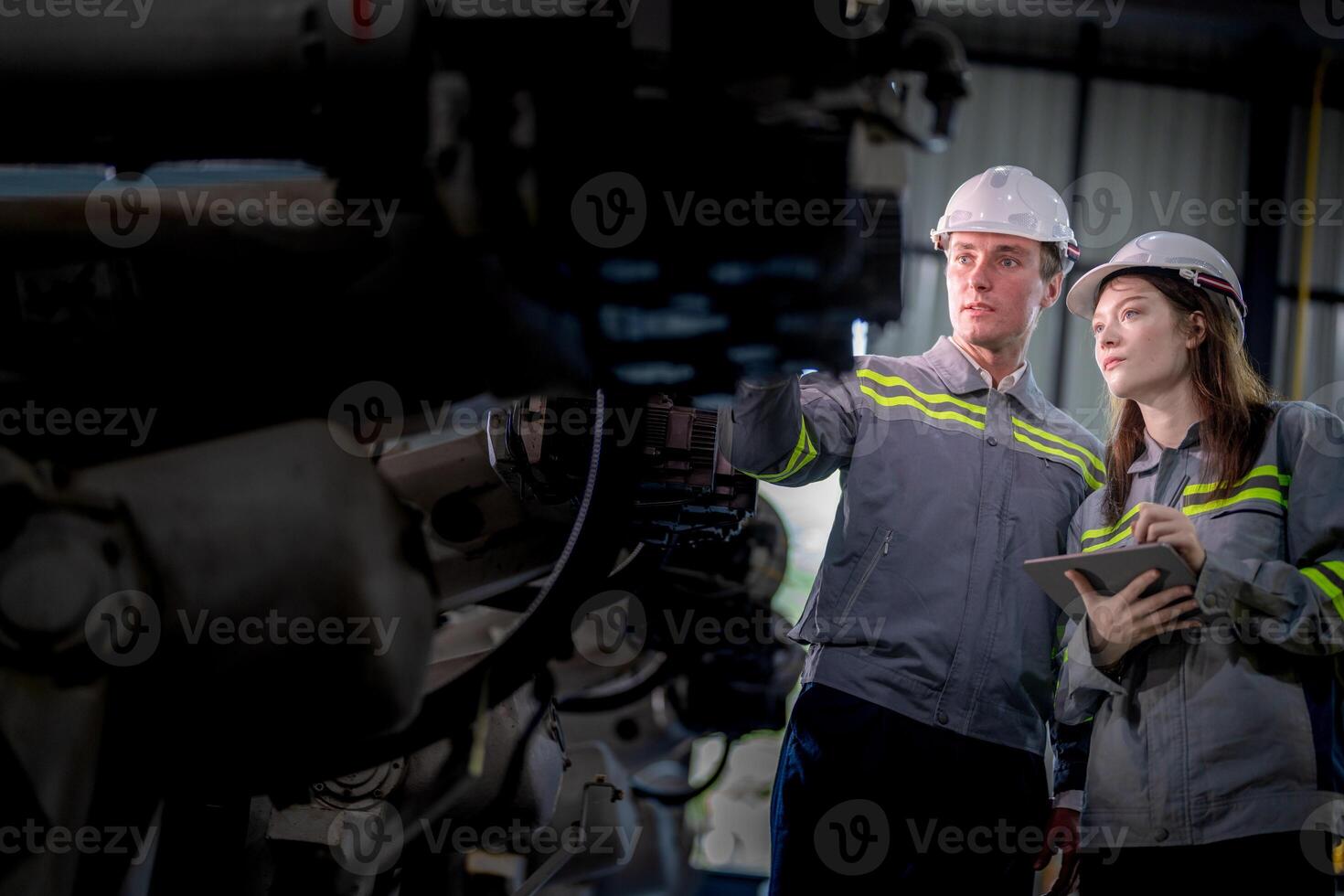 engineers check control heavy machine robot arm. Diverse Team of Industrial Robotics Engineers Gathered Around Machine. Professional Machinery Operators repair electric robot on bright digital panel. photo