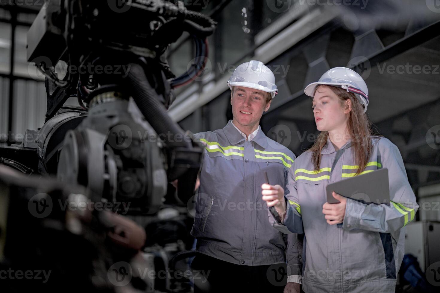 Sales manager and factory owner in suits negotiating selling robots used in the factory. Business engineers meeting and checking new machine robot. Workers walking at warehouse welding machine. photo