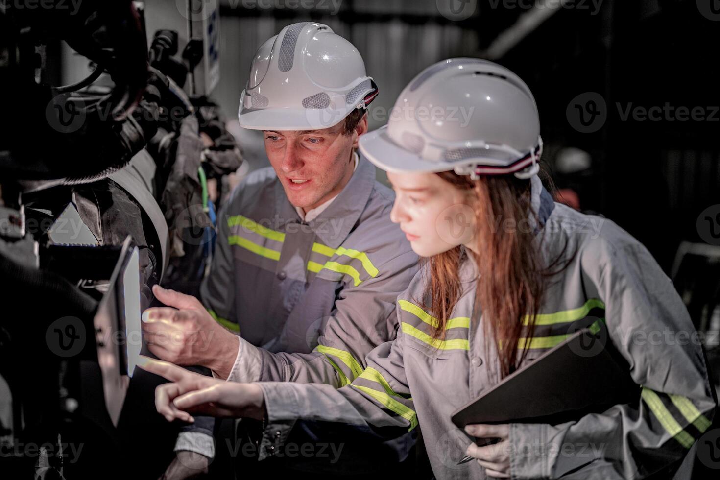 Sales manager and factory owner in suits negotiating selling robots used in the factory. Business engineers meeting and checking new machine robot. Workers walking at warehouse welding machine. photo