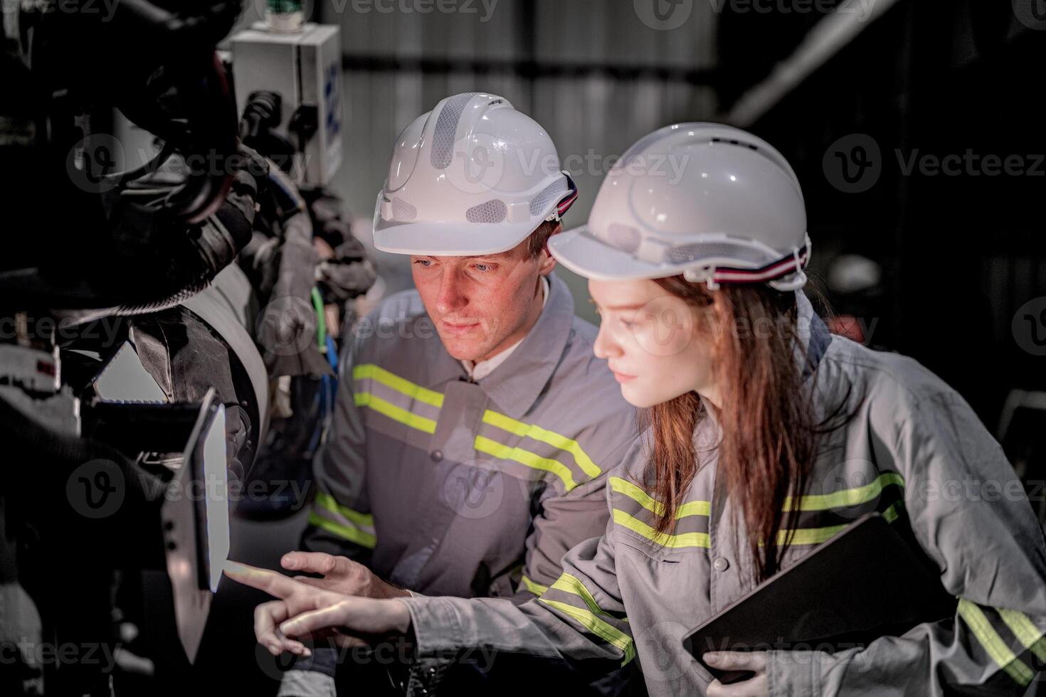 Sales manager and factory owner in suits negotiating selling robots used in the factory. Business engineers meeting and checking new machine robot. Workers walking at warehouse welding machine. photo