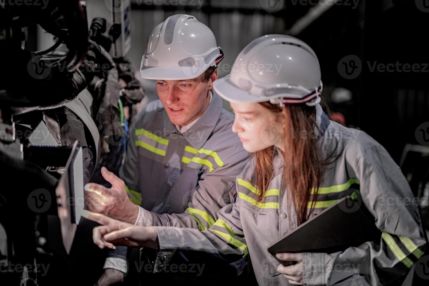 Sales manager and factory owner in suits negotiating selling robots used in the factory. Business engineers meeting and checking new machine robot. Workers walking at warehouse welding machine. photo