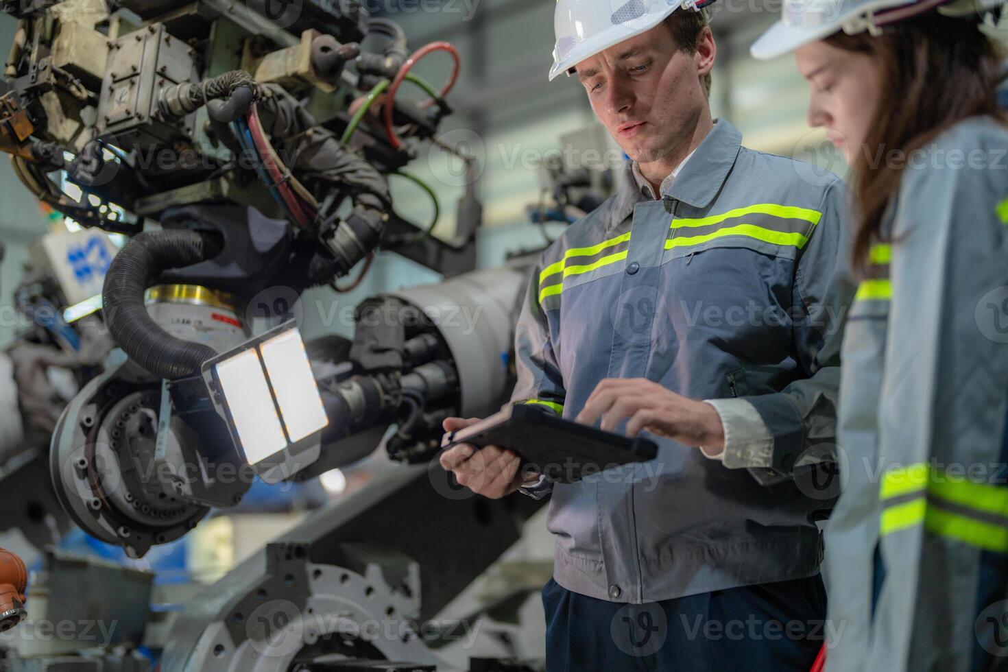 engineers check control heavy machine robot arm. Diverse Team of Industrial Robotics Engineers Gathered Around Machine. Professional Machinery Operators repair electric robot on bright digital panel. photo