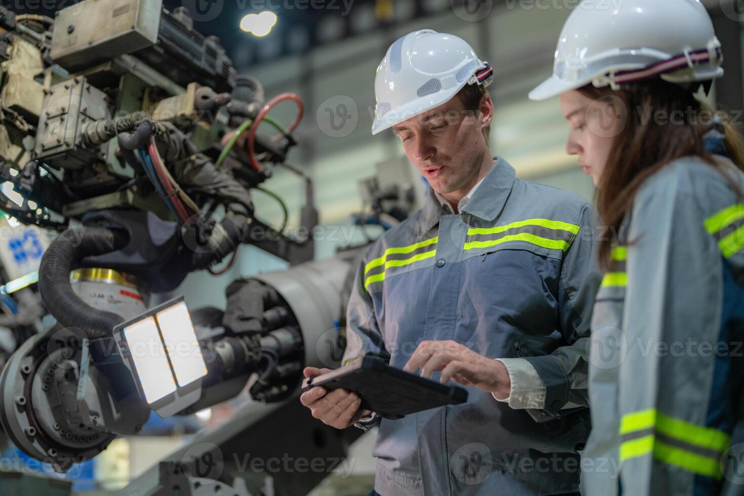 engineers check control heavy machine robot arm. Diverse Team of Industrial Robotics Engineers Gathered Around Machine. Professional Machinery Operators repair electric robot on bright digital panel. photo