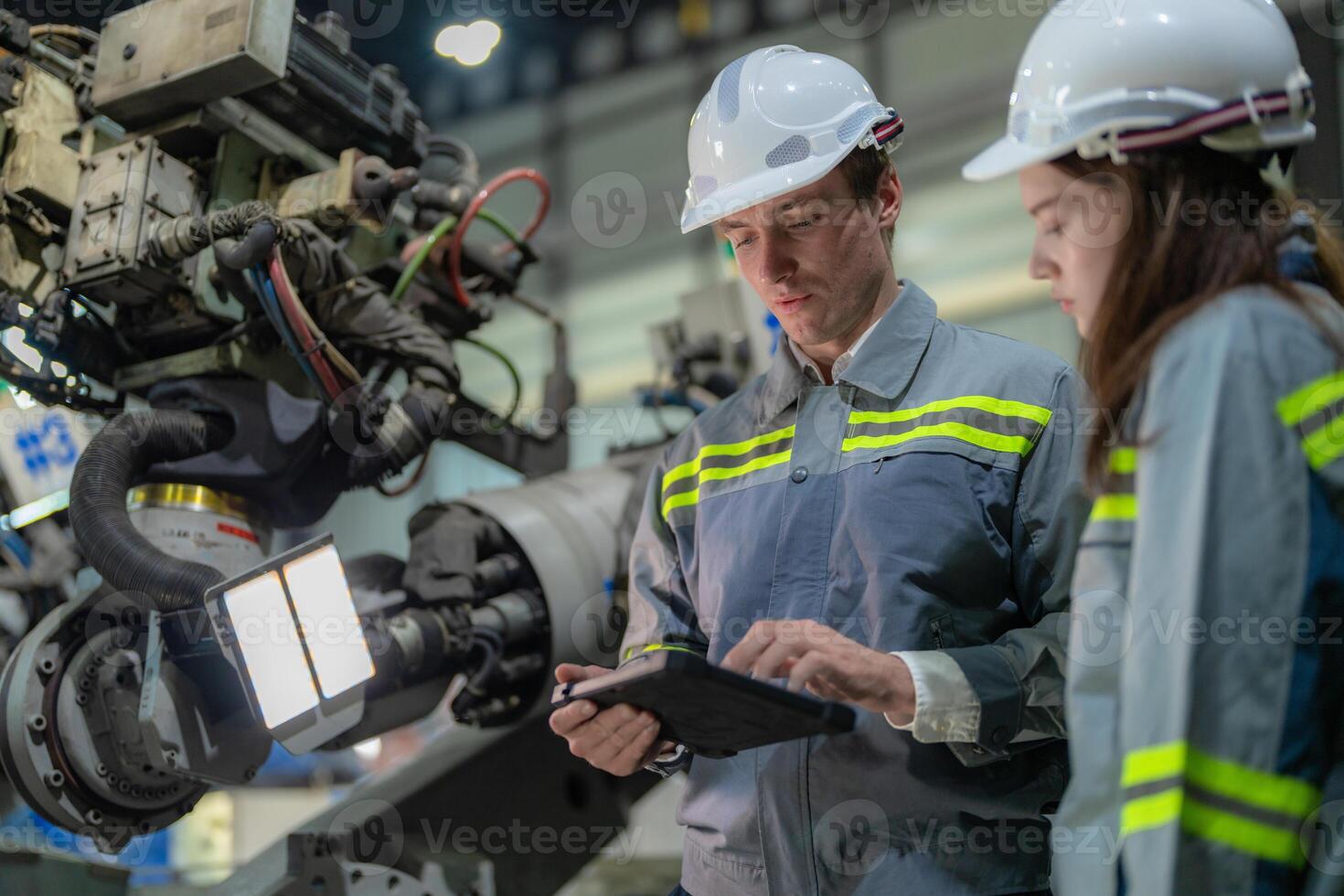engineers check control heavy machine robot arm. Diverse Team of Industrial Robotics Engineers Gathered Around Machine. Professional Machinery Operators repair electric robot on bright digital panel. photo