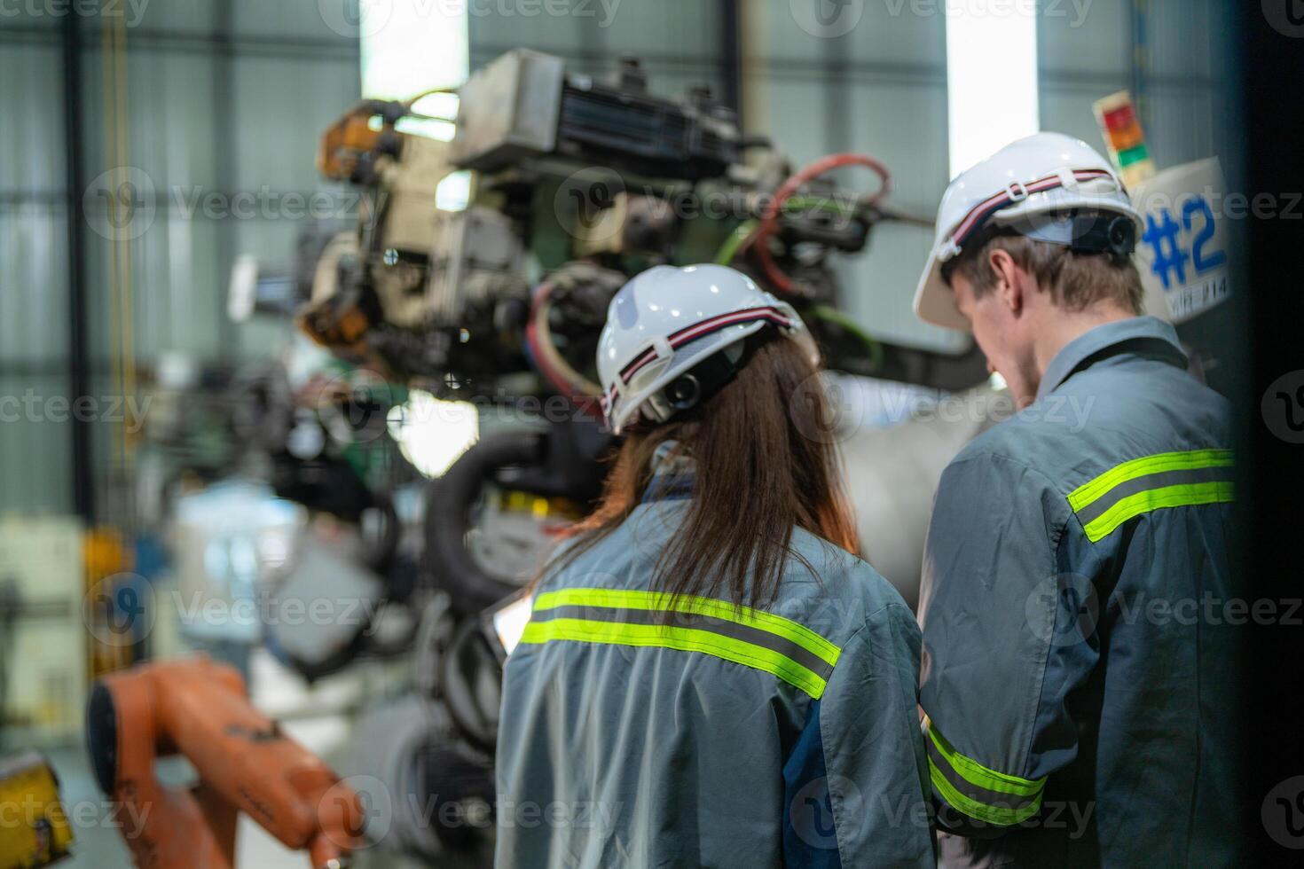 ingenieros cheque controlar pesado máquina robot brazo. diverso equipo de industrial robótica ingenieros reunido alrededor máquina. profesional maquinaria operadores reparar eléctrico robot en brillante digital panel. foto