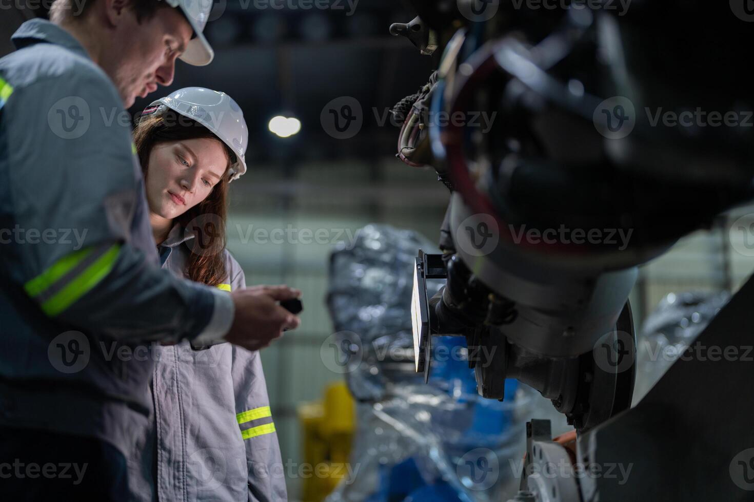engineers check control heavy machine robot arm. Diverse Team of Industrial Robotics Engineers Gathered Around Machine. Professional Machinery Operators repair electric robot on bright digital panel. photo