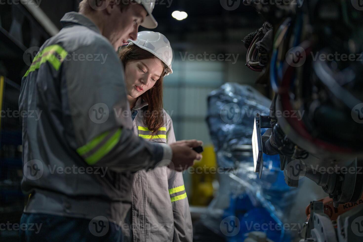 engineers check control heavy machine robot arm. Diverse Team of Industrial Robotics Engineers Gathered Around Machine. Professional Machinery Operators repair electric robot on bright digital panel. photo