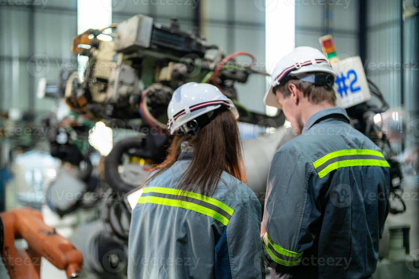 engineers check control heavy machine robot arm. Diverse Team of Industrial Robotics Engineers Gathered Around Machine. Professional Machinery Operators repair electric robot on bright digital panel. photo
