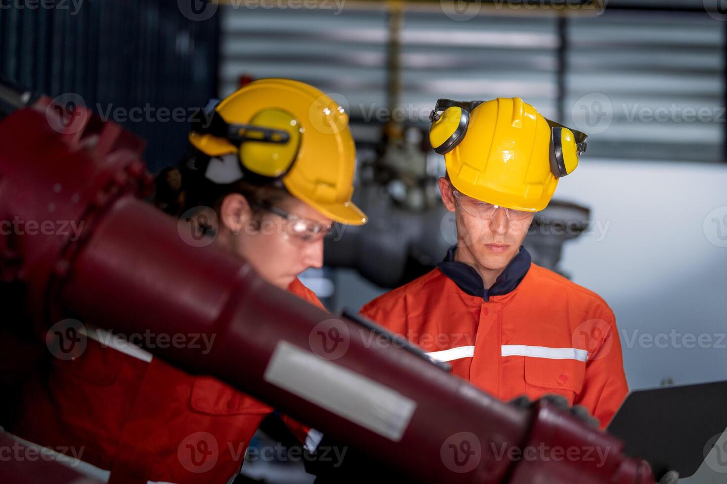 group of male engineer workers maintenance automatic robotic arm machine in a dark room factory. worker checking and repairing automatic robot hand machine. Worker wearing safety glasses and helmet. photo