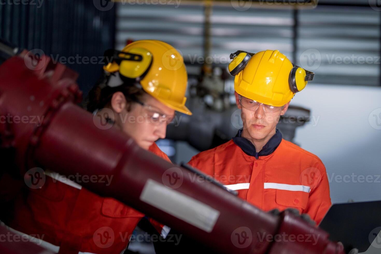group of male engineer workers maintenance automatic robotic arm machine in a dark room factory. worker checking and repairing automatic robot hand machine. Worker wearing safety glasses and helmet. photo