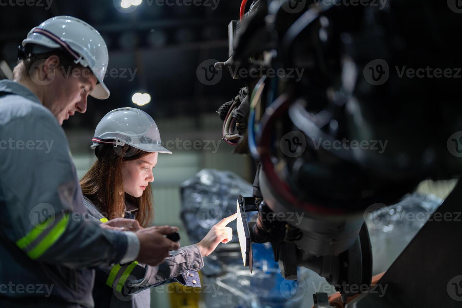 engineers check control heavy machine robot arm. Diverse Team of Industrial Robotics Engineers Gathered Around Machine. Professional Machinery Operators repair electric robot on bright digital panel. photo