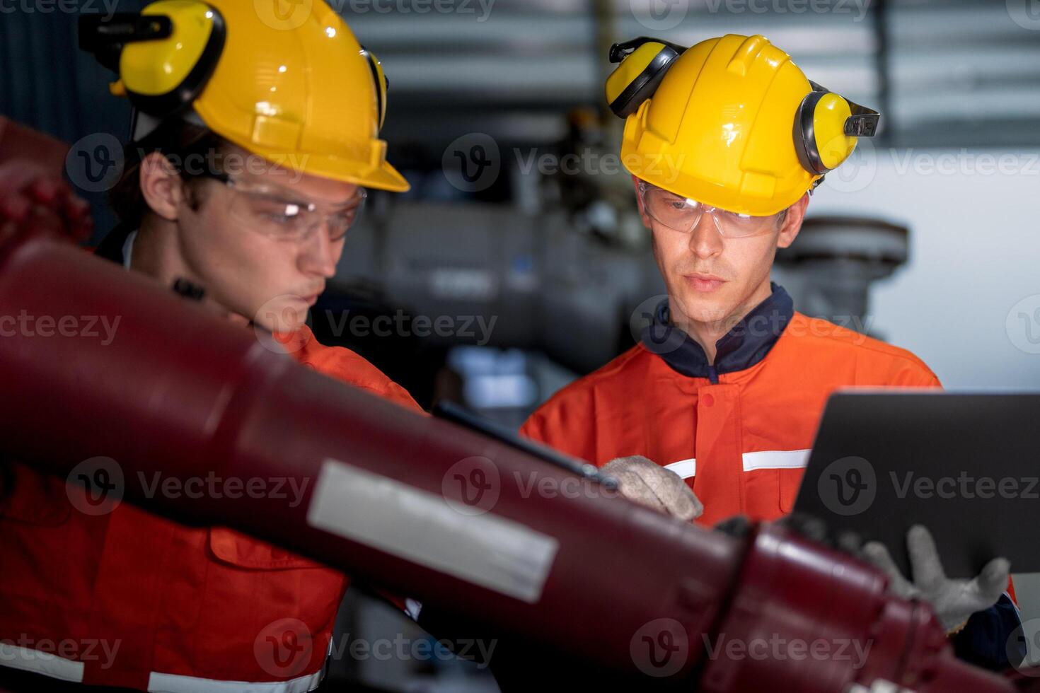 group of male engineer workers maintenance automatic robotic arm machine in a dark room factory. worker checking and repairing automatic robot hand machine. Worker wearing safety glasses and helmet. photo