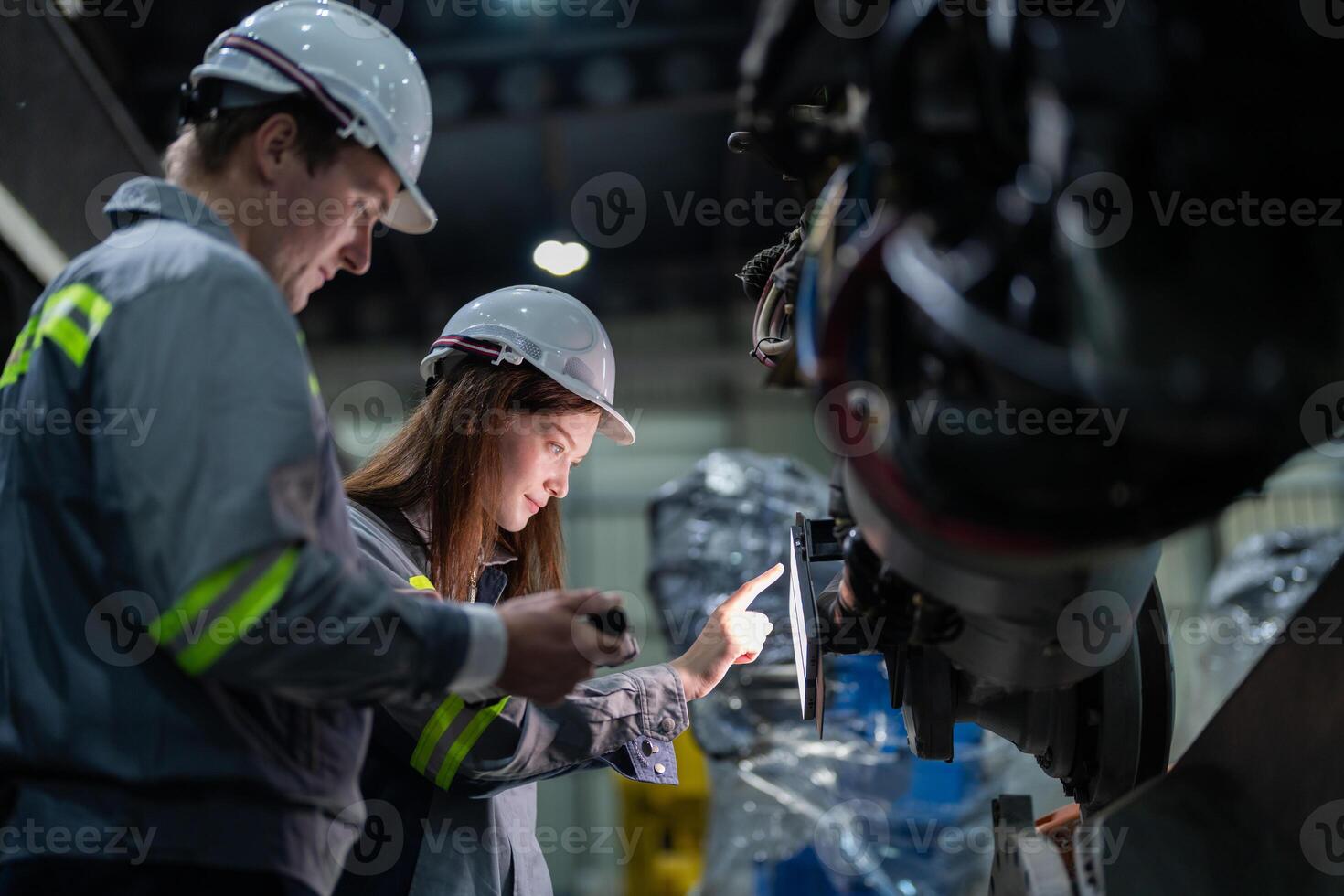 engineers check control heavy machine robot arm. Diverse Team of Industrial Robotics Engineers Gathered Around Machine. Professional Machinery Operators repair electric robot on bright digital panel. photo