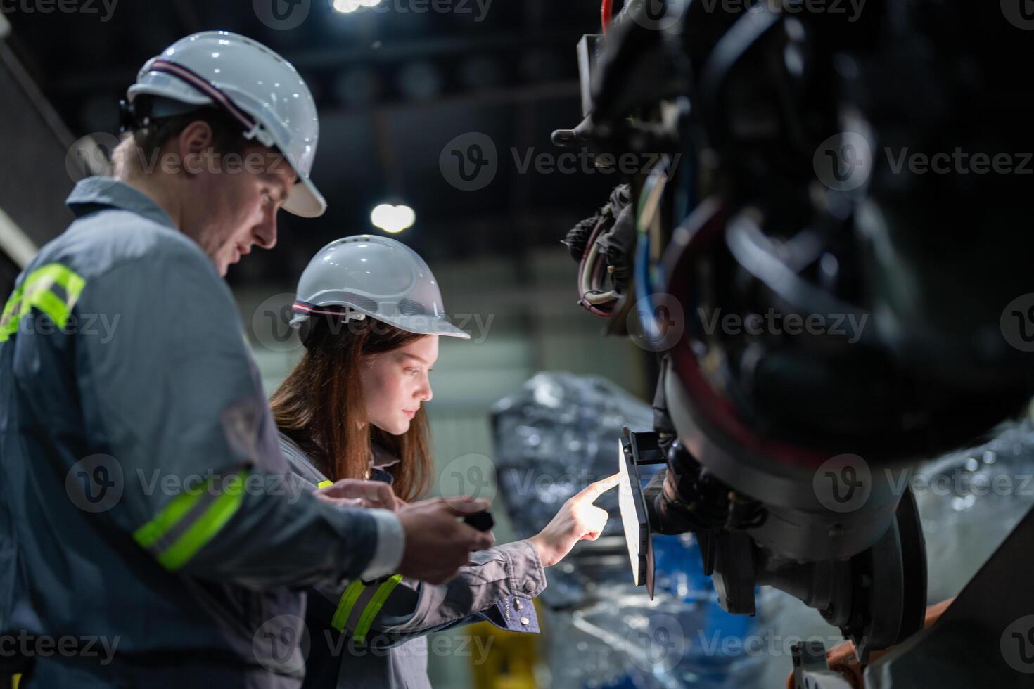 engineers check control heavy machine robot arm. Diverse Team of Industrial Robotics Engineers Gathered Around Machine. Professional Machinery Operators repair electric robot on bright digital panel. photo