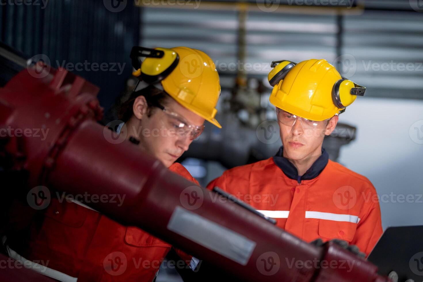 group of male engineer workers maintenance automatic robotic arm machine in a dark room factory. worker checking and repairing automatic robot hand machine. Worker wearing safety glasses and helmet. photo