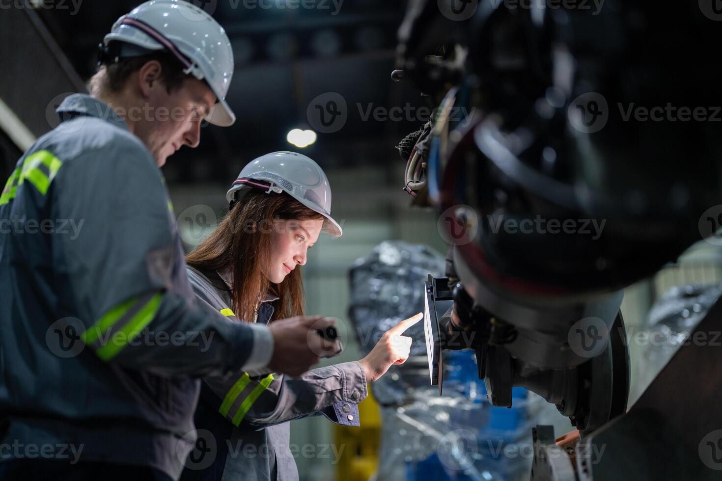 engineers check control heavy machine robot arm. Diverse Team of Industrial Robotics Engineers Gathered Around Machine. Professional Machinery Operators repair electric robot on bright digital panel. photo