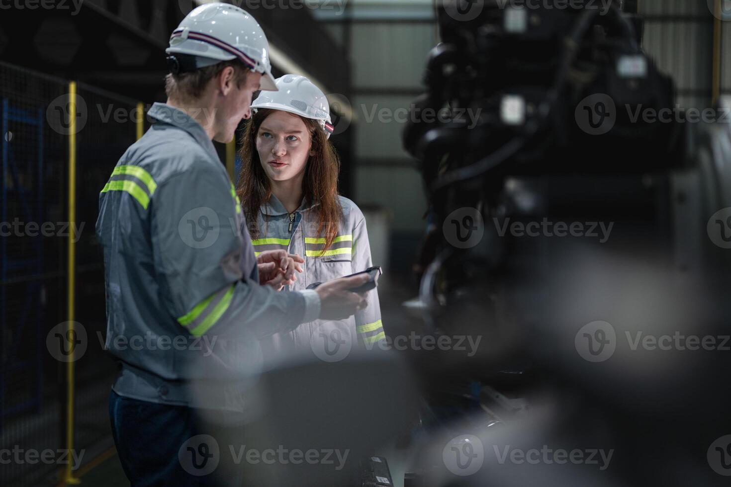 engineers check control heavy machine robot arm. Diverse Team of Industrial Robotics Engineers Gathered Around Machine. Professional Machinery Operators repair electric robot on bright digital panel. photo