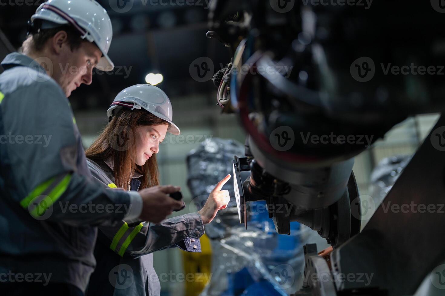 engineers check control heavy machine robot arm. Diverse Team of Industrial Robotics Engineers Gathered Around Machine. Professional Machinery Operators repair electric robot on bright digital panel. photo