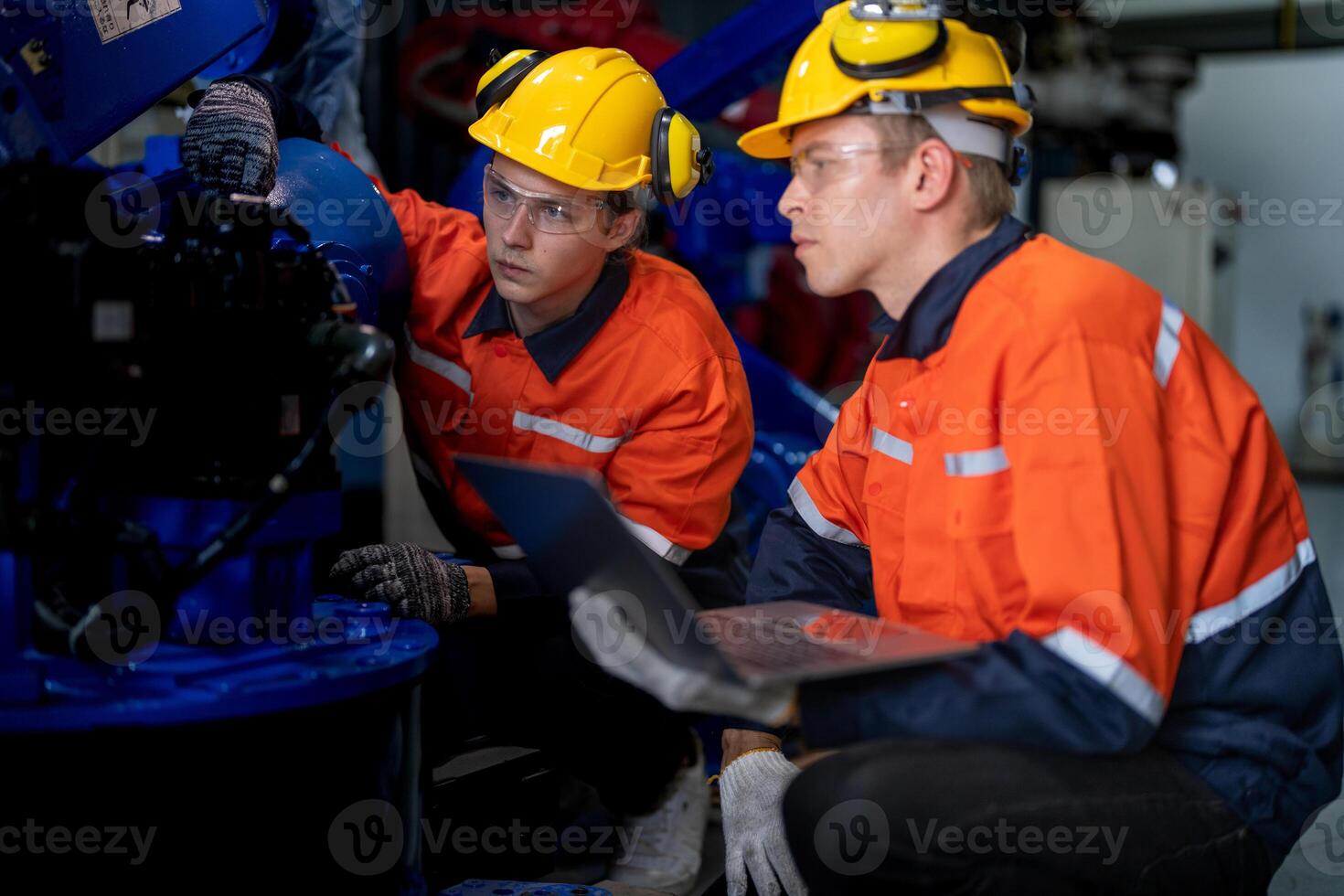 Business engineers meet and check control heavy machine robot arm. Diverse Team of Industrial Robotics Engineers Gathered Around machine. Professional Machinery Operator Use Industrial Digital Tablet. photo