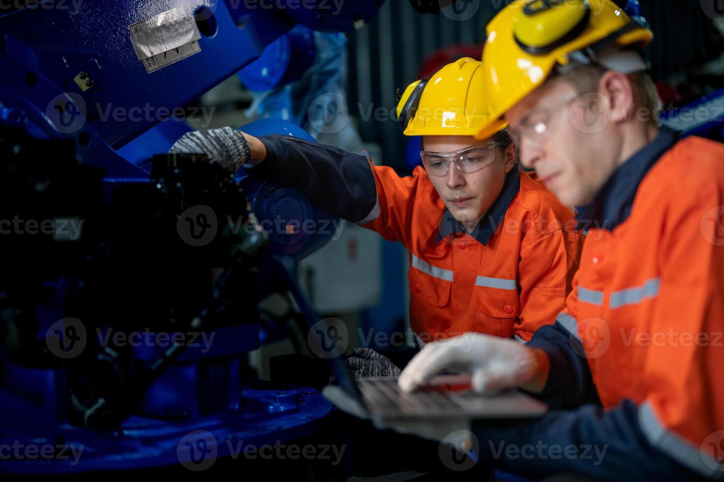 Business engineers meet and check control heavy machine robot arm. Diverse Team of Industrial Robotics Engineers Gathered Around machine. Professional Machinery Operator Use Industrial Digital Tablet. photo
