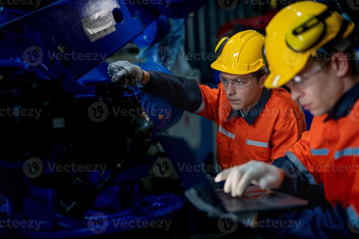 Business engineers meet and check control heavy machine robot arm. Diverse Team of Industrial Robotics Engineers Gathered Around machine. Professional Machinery Operator Use Industrial Digital Tablet. photo