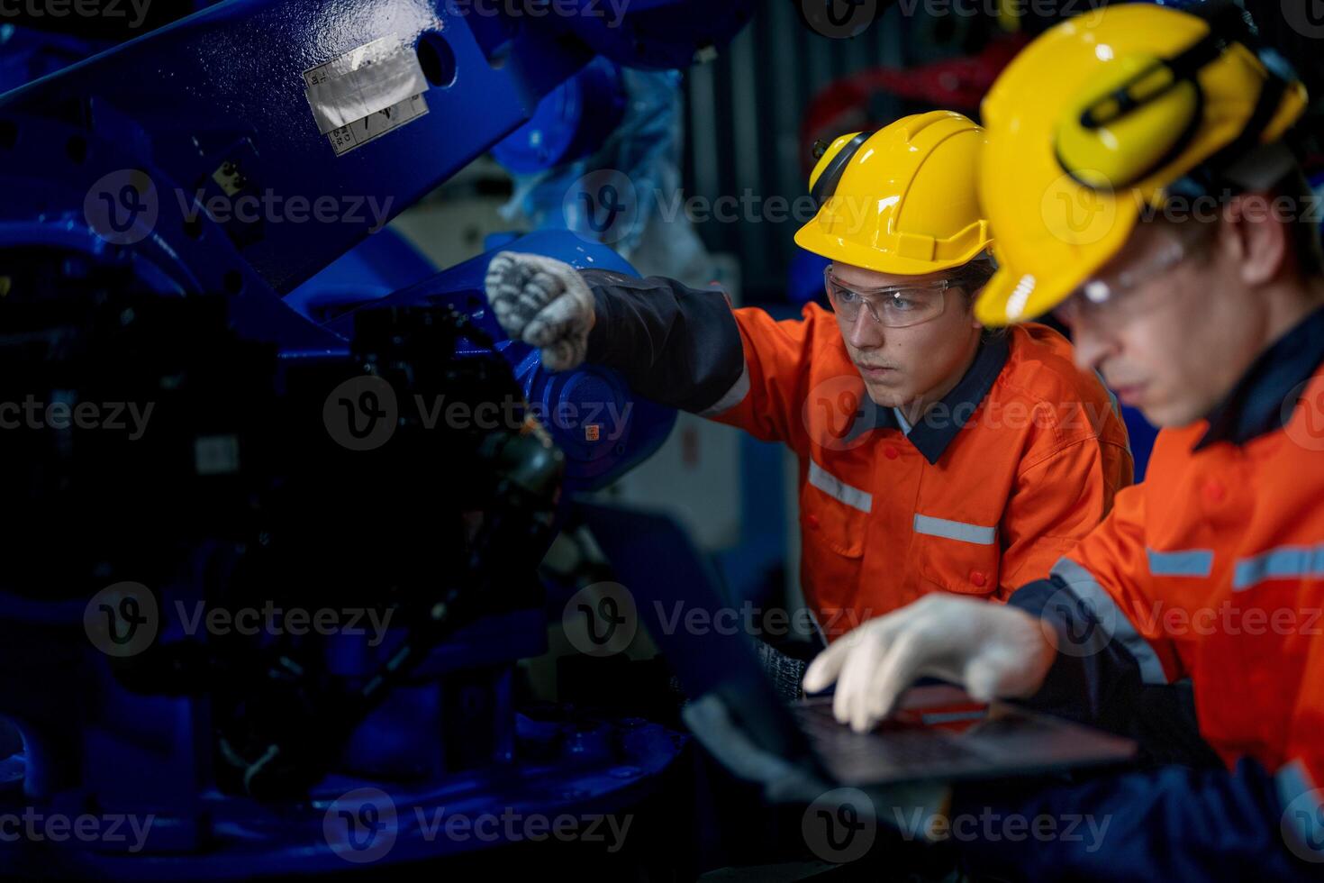 Business engineers meet and check control heavy machine robot arm. Diverse Team of Industrial Robotics Engineers Gathered Around machine. Professional Machinery Operator Use Industrial Digital Tablet. photo