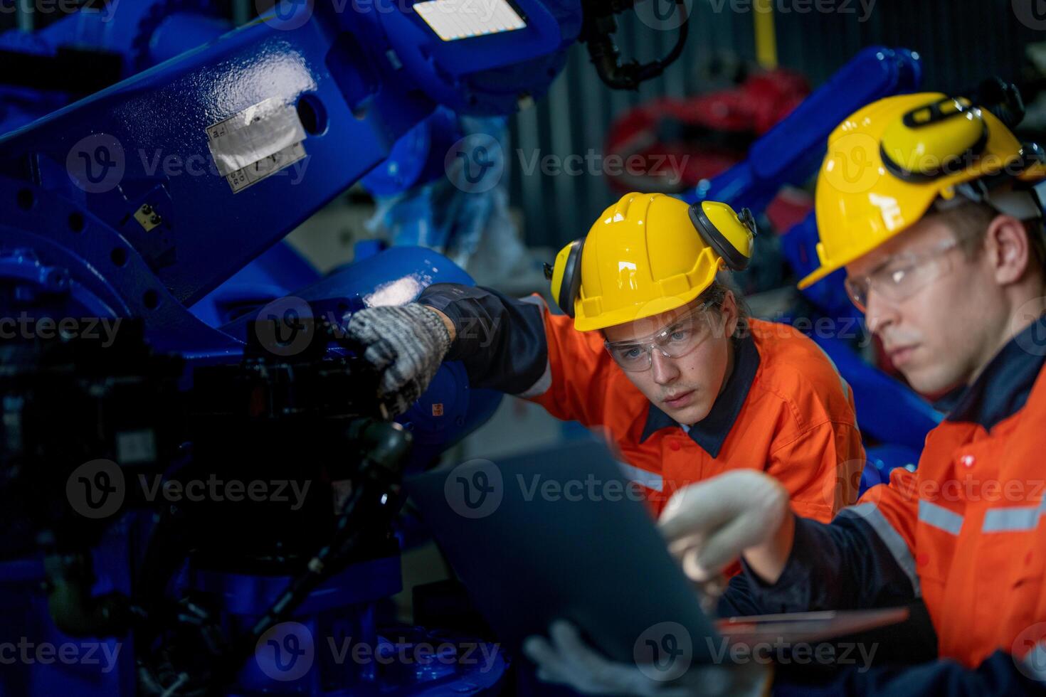 Business engineers meet and check control heavy machine robot arm. Diverse Team of Industrial Robotics Engineers Gathered Around machine. Professional Machinery Operator Use Industrial Digital Tablet. photo