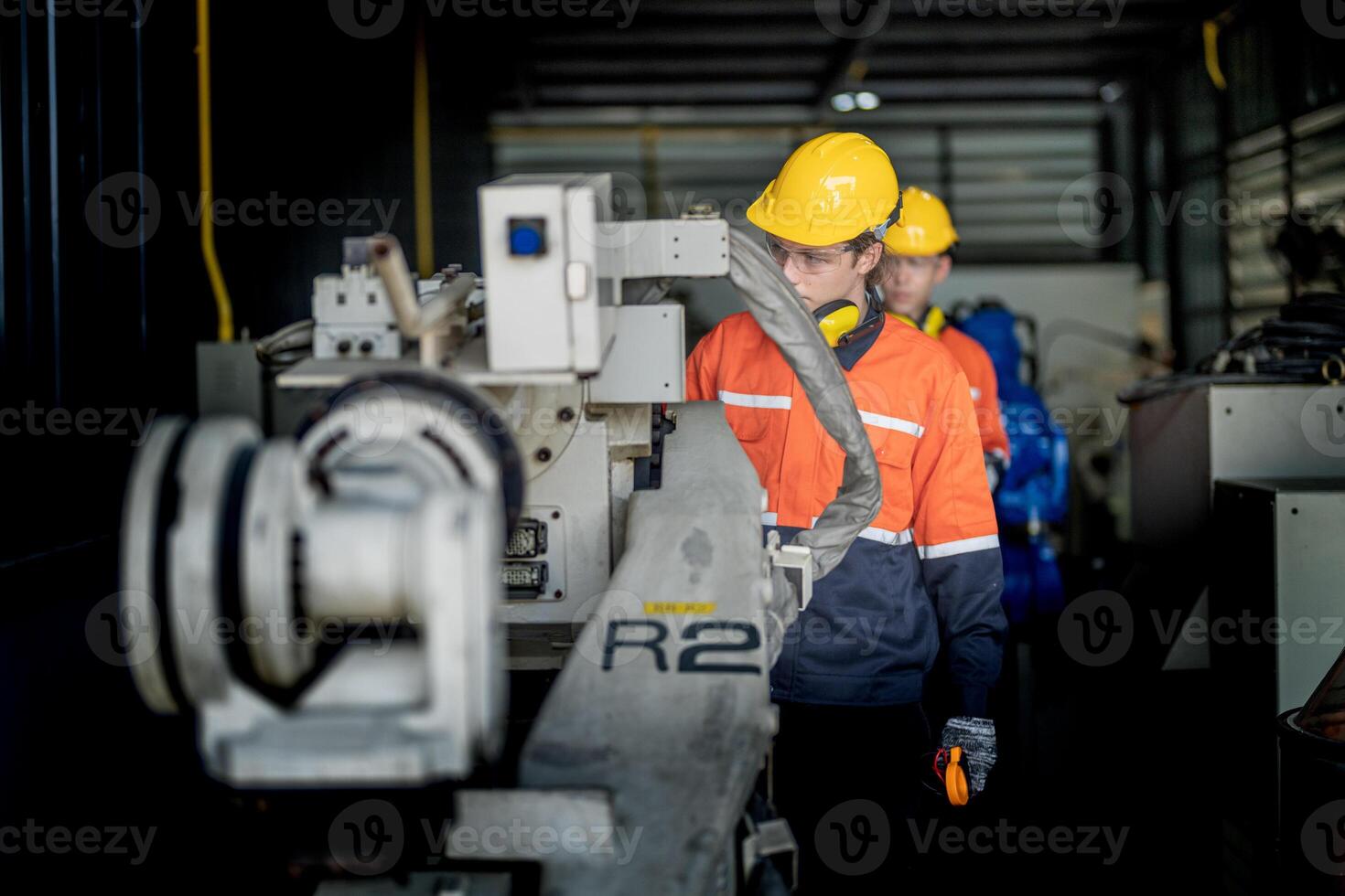 male engineer workers maintenance automatic robotic arm machine in a factory. worker checking and repairing automatic robot hand machine. technician worker check for repair factory machine. photo
