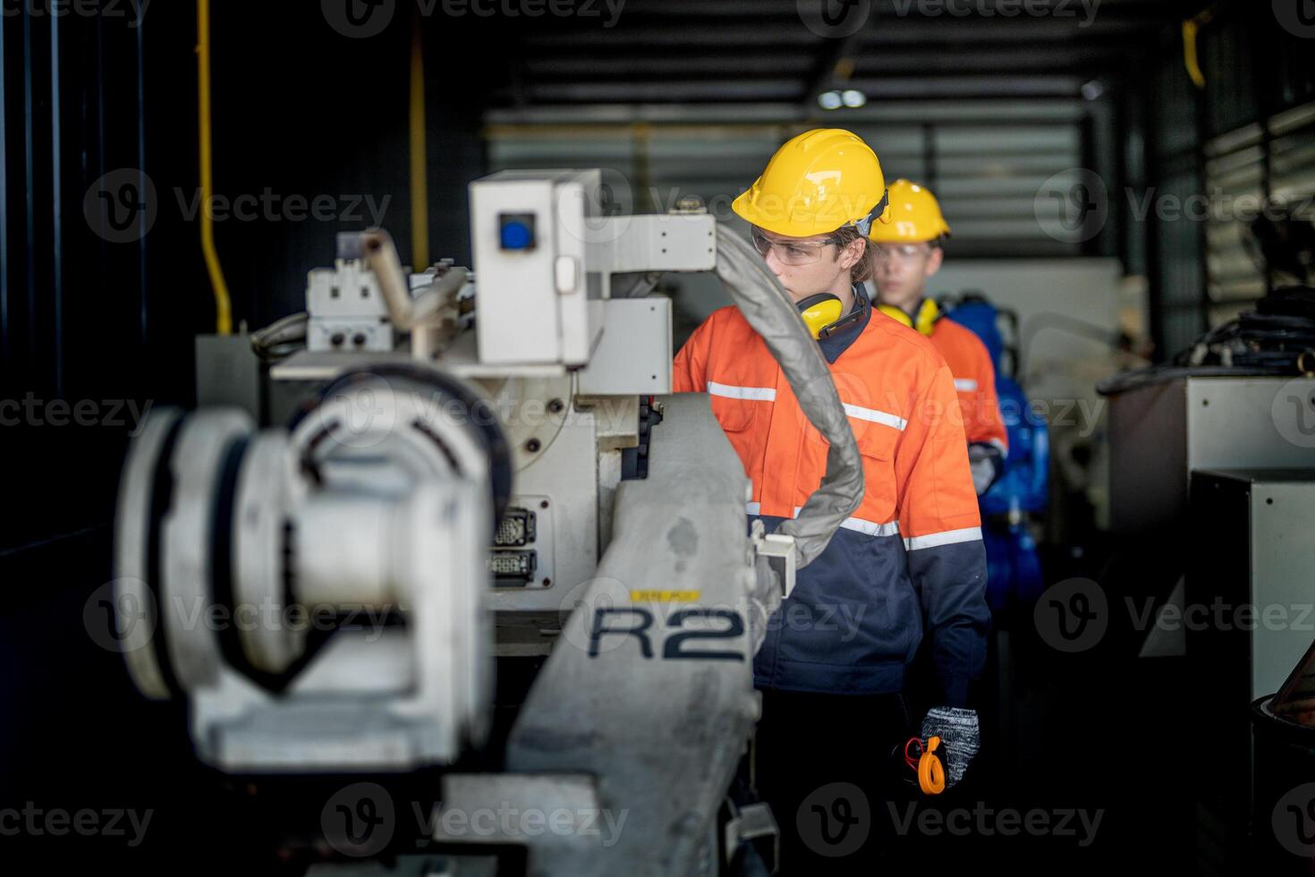 male engineer workers maintenance automatic robotic arm machine in a factory. worker checking and repairing automatic robot hand machine. technician worker check for repair factory machine. photo