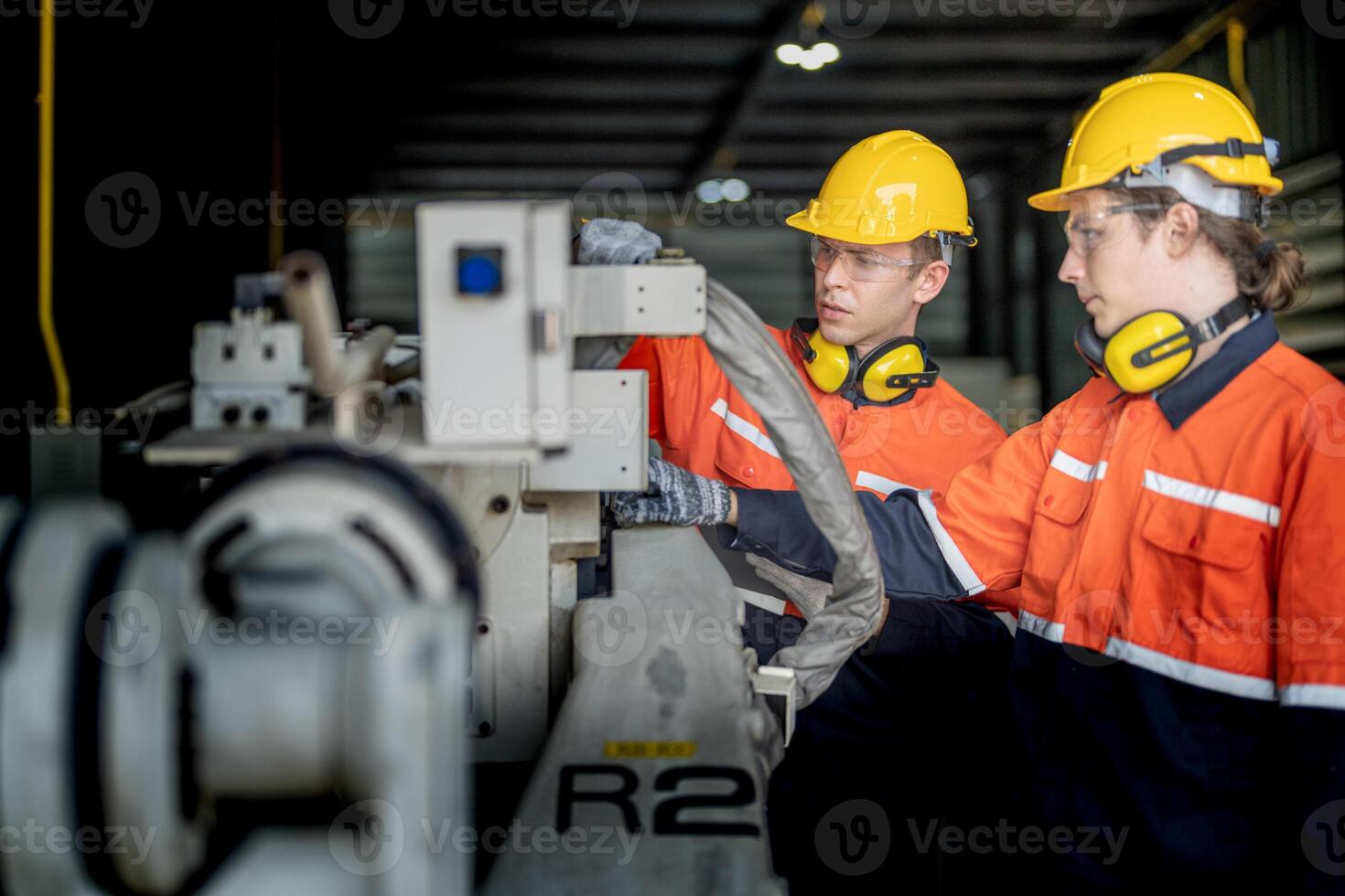 male engineer workers maintenance automatic robotic arm machine in a factory. worker checking and repairing automatic robot hand machine. technician worker check for repair factory machine. photo