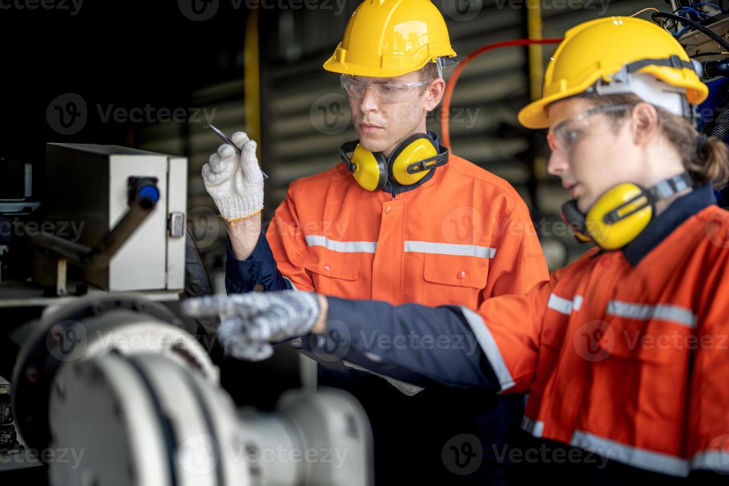 male engineer workers maintenance automatic robotic arm machine in a factory. worker checking and repairing automatic robot hand machine. technician worker check for repair factory machine. photo