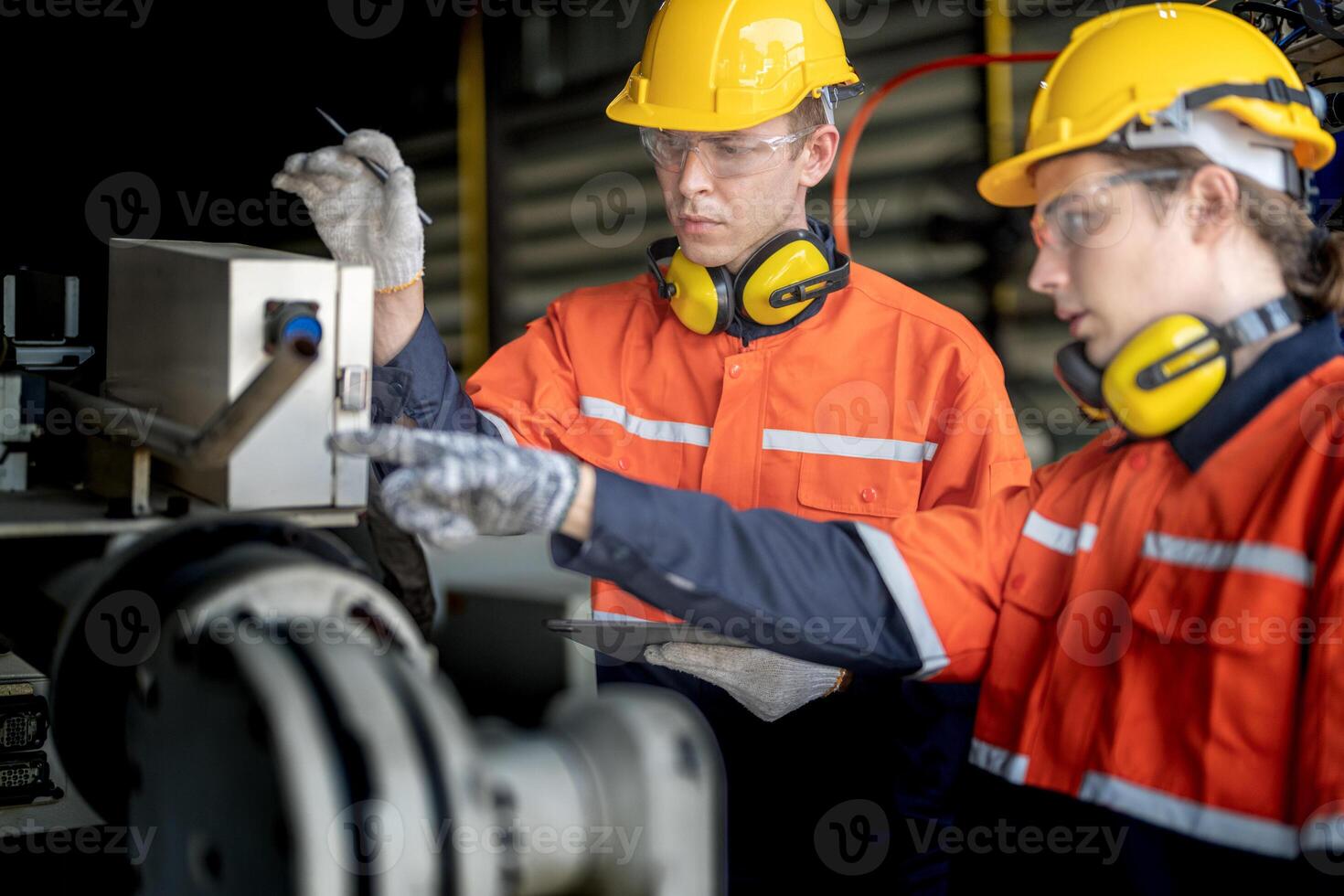 male engineer workers maintenance automatic robotic arm machine in a factory. worker checking and repairing automatic robot hand machine. technician worker check for repair factory machine. photo