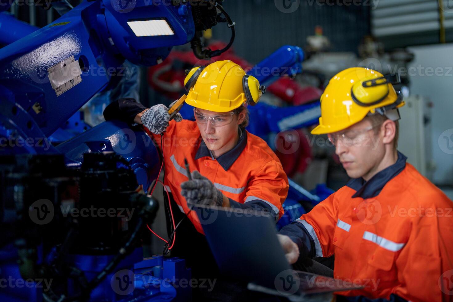 male engineer workers maintenance automatic robotic arm machine in a factory. worker checking and repairing automatic robot hand machine. technician worker check for repair factory machine. photo