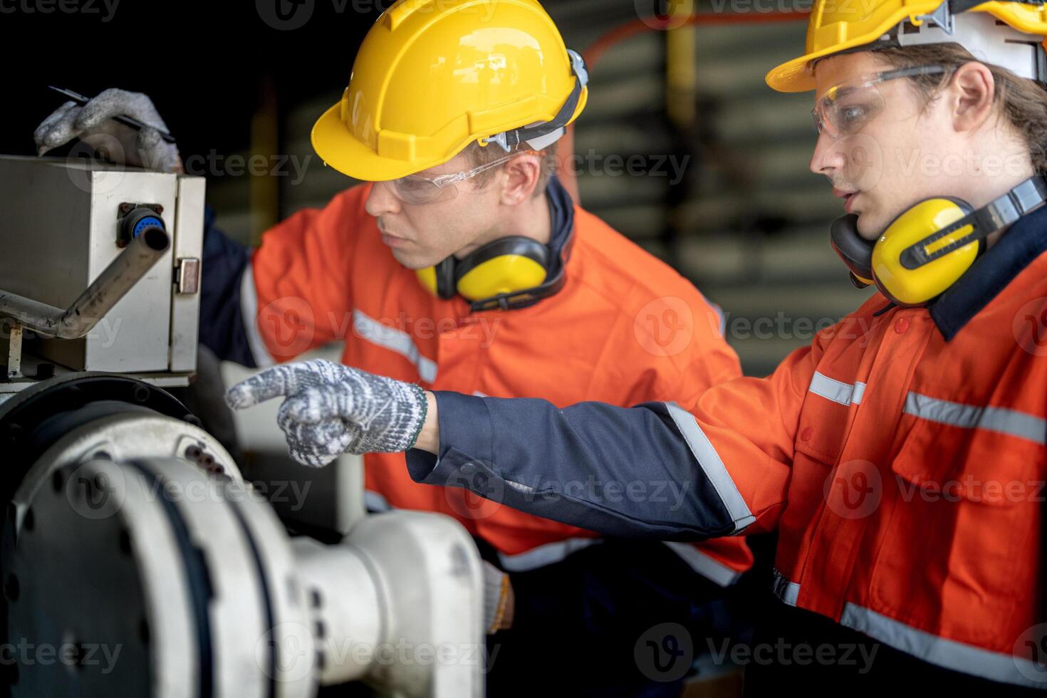 male engineer workers maintenance automatic robotic arm machine in a factory. worker checking and repairing automatic robot hand machine. technician worker check for repair factory machine. photo